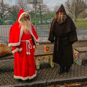 Two men dressed up in costumes of Swiss Santa Samichlaus and his helper Schmutzli