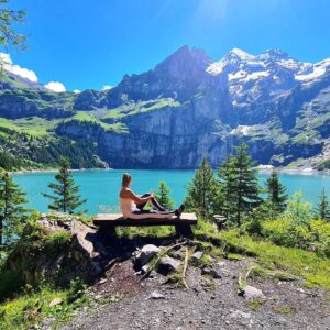 oeschinensee girl sitting on the bench overlooking the lake